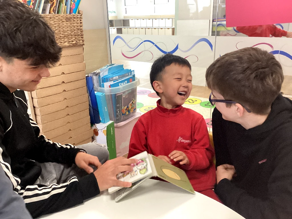 Un alumne d'ESO llegeix un conte a un nen d'Infantil durant una sessió de parelles lectores.