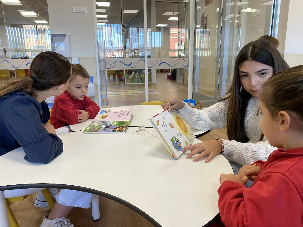 Alumnes de l'ESO i d'infantil durant una sessió d'apadrinament lector