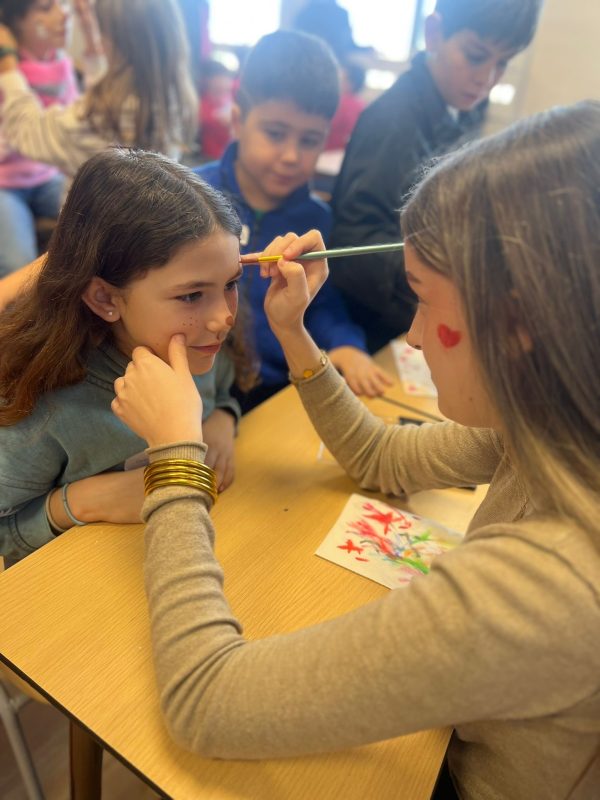 Alumnat gaudint del taller de pinta-cares durant la jornada de convivència escolar